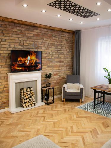 a living room with a fireplace and a brick wall at Season One Apartman in Szeged