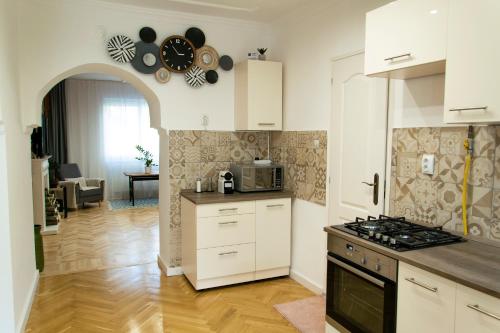 a kitchen with white cabinets and a stove top oven at Season One Apartman in Szeged