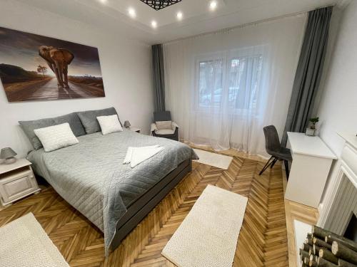 a bedroom with a bed and a painting of an elephant at Season One Apartman in Szeged