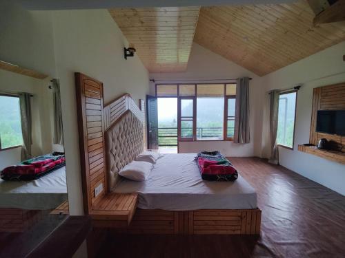 a bedroom with two beds in a room with windows at Cabin in the Woods in Vashisht