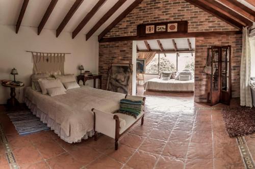 1 dormitorio con 1 cama grande y pared de ladrillo en Acogedora Casa Campestre en Chia BBQ Parqueadero Privado incluido, en Chía