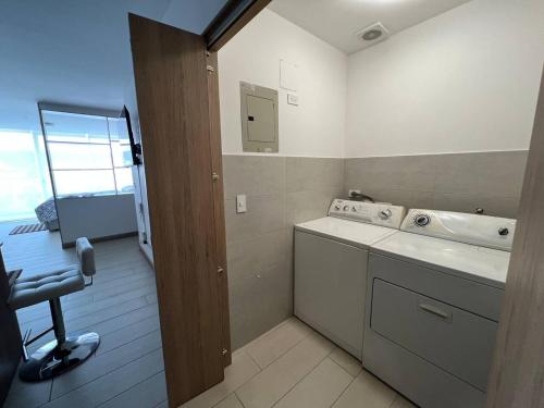 a bathroom with a sink and a washing machine at LovelyView Studio Edif 1 HeatedPool Gym Turco WIFI 1412 in Quito