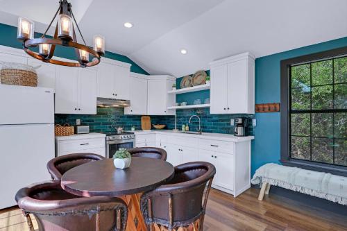 a kitchen with white cabinets and a table and chairs at Terlingua at the Bend in Wimberley
