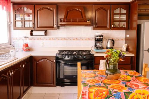 a kitchen with a table with a vase of flowers on it at Spacious artsy home with fast WiFi in Oaxaca City