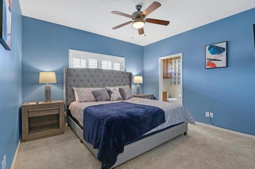 - une chambre bleue avec un lit et un ventilateur de plafond dans l'établissement Moon River, à New Braunfels
