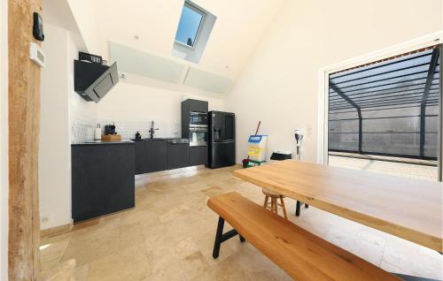 a kitchen with a wooden table and a large window at Le Loft De La Grange in Léglantiers