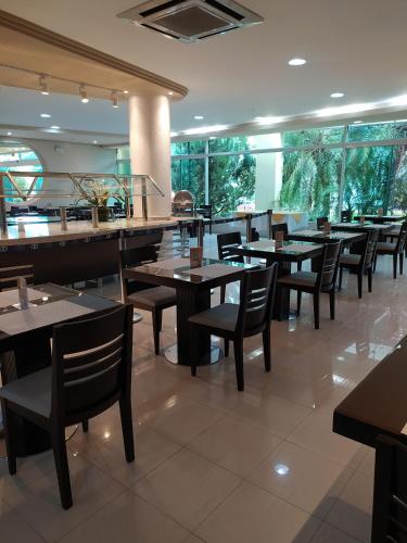 a dining room with tables and chairs in a restaurant at Hotel Aliança Express in Rio do Sul