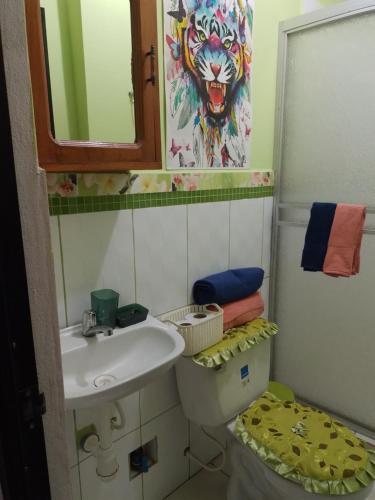 W łazience znajduje się umywalka, toaleta i lustro. w obiekcie HABITACIÓN AMUEBLADA Y ACOGEDORA w mieście Puerto Callao