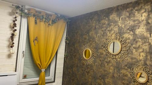 La salle de bains est pourvue d'un rideau de douche jaune et d'un miroir. dans l'établissement Un petit coin de Paradis, à Toulouse