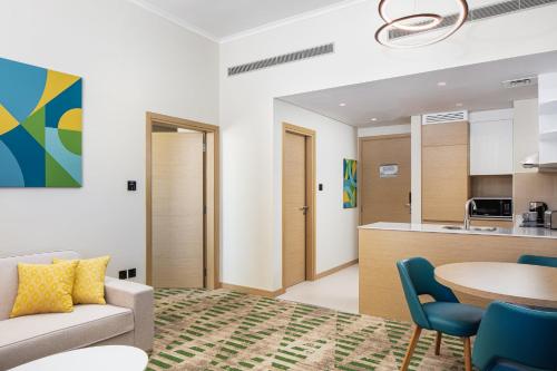 a living room with a couch and a table at Holiday Inn & Suites - Dubai Science Park by IHG in Dubai
