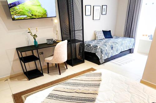 a bedroom with a desk and a bed and a television at Luxury Home In Aguacatala in Medellín
