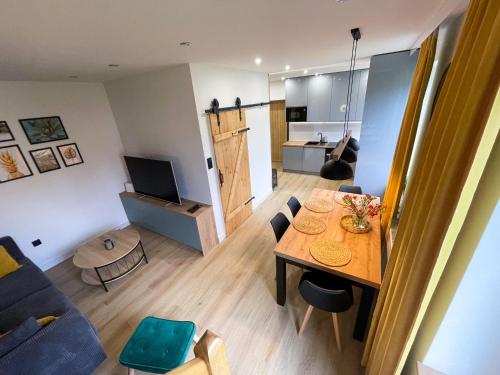 - un salon avec une table et un canapé dans l'établissement Apartament Kamienica Loft, à Kudowa-Zdrój