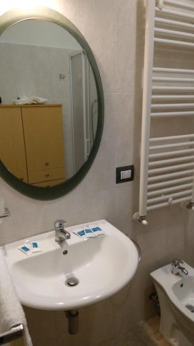 ein Badezimmer mit einem weißen Waschbecken und einem Spiegel in der Unterkunft Casa Momo in Montecchio