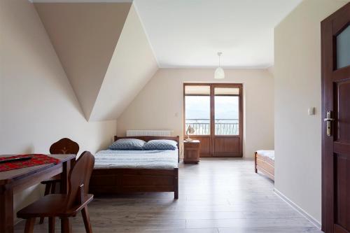 - une chambre avec un lit, une table et une fenêtre dans l'établissement Pokoje Gościnne Panorama, à Rzepiska