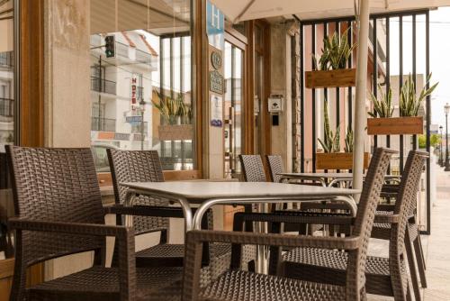 una fila de mesas y sillas en un restaurante en Hotel Caribe Sanxenxo, en Sanxenxo