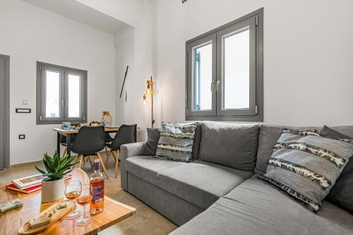 a living room with a gray couch and a table at Zana's Villa-Sandra in Akrotiri