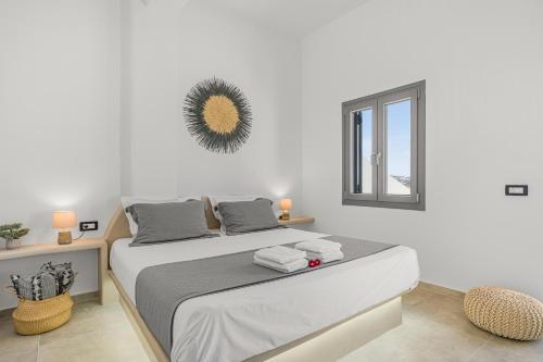 a white bedroom with a bed and a window at Zana's Villa-Sandra in Akrotiri