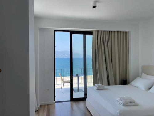 a bedroom with a bed and a view of the ocean at Swiss Rivage Hotel in Vlorë
