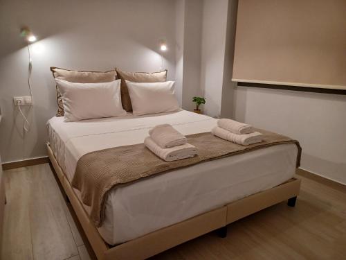 a large white bed with two towels on it at Amelia Luxury Suite in Nikiana