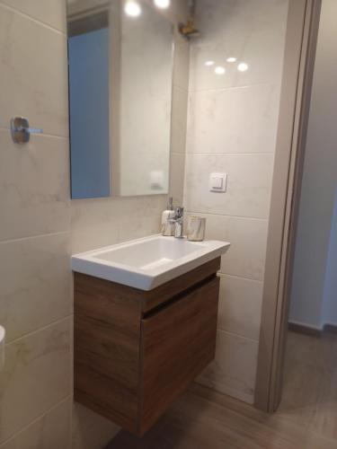 bagno con lavandino bianco e specchio di Amelia Luxury Suite a Nikiana