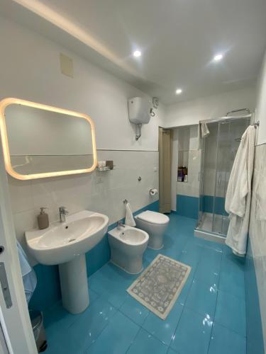 ein Badezimmer mit einem Waschbecken, einem WC und einem Spiegel in der Unterkunft La Casetta dei Sogni in Procida