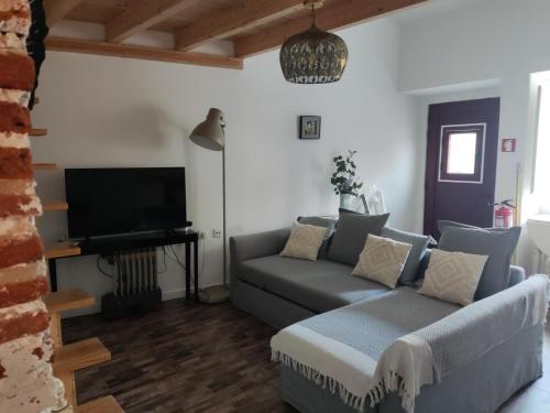 a living room with a couch and a flat screen tv at Poial da Bia in Mértola