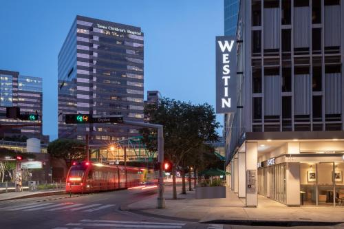 a train on a street in a city at night at The Westin Houston Medical Center - Museum District in Houston