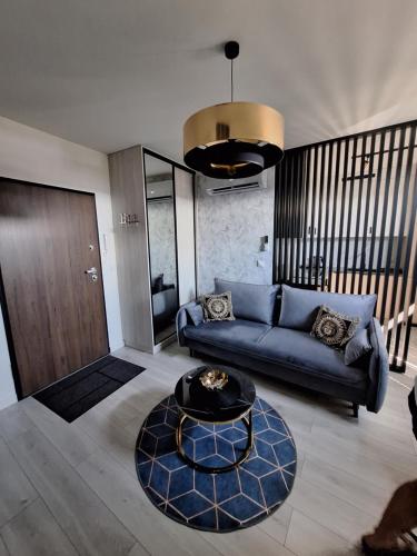 a living room with a blue couch and a table at ApartPort nowoczesne apartamenty in Gdynia
