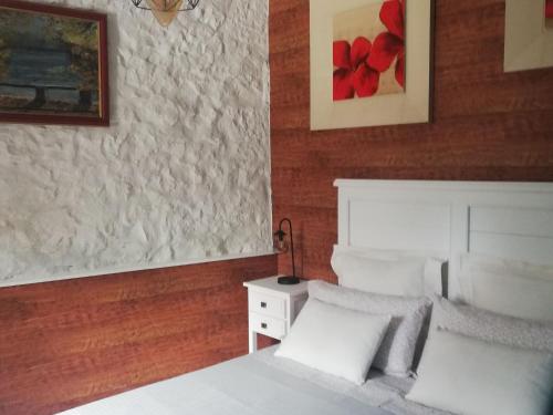 a bedroom with a white bed and a red wall at Vibrant holiday home in Villanueva with terrace in Villanueva