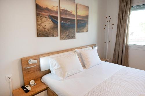 een slaapkamer met een bed met vier schilderijen aan de muur bij Villa Sofia Sea View in Poros