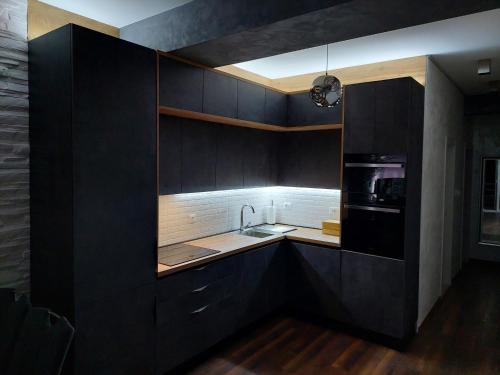 a kitchen with black cabinets and a sink at Apartment Antea in Split
