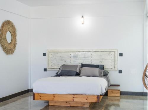 1 dormitorio con 1 cama con cabecero de madera en Las Gemelas del Mar en El Cotillo