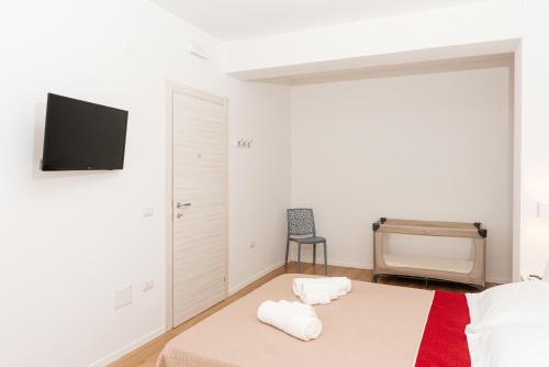 a bedroom with a bed and a tv on the wall at La Casa di Ambra in Porto Torres