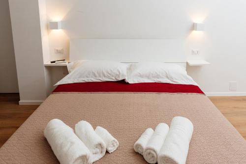 a bed with three white towels on it at La Casa di Ambra in Porto Torres