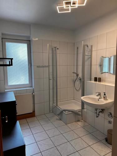 a bathroom with a shower and a sink and a tub at Ferienwohnungen Café Cup in Detmold