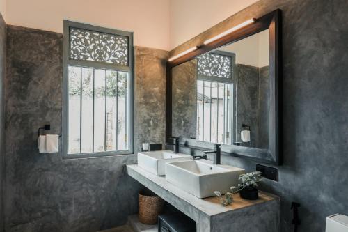 łazienka z 2 umywalkami i dużym lustrem w obiekcie Moi Talpe by DBI w mieście Talpe
