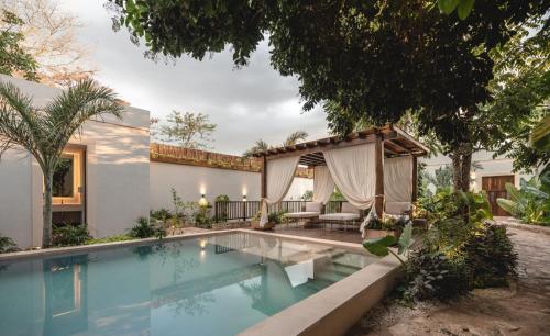 einen Pool mit Pavillon neben einem Haus in der Unterkunft Hotel Sutuk in Valladolid