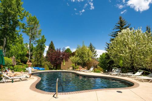 a swimming pool with people sitting in chairs around it at Seasons Four 172 Two bedroom plus loft in Snowmass Village