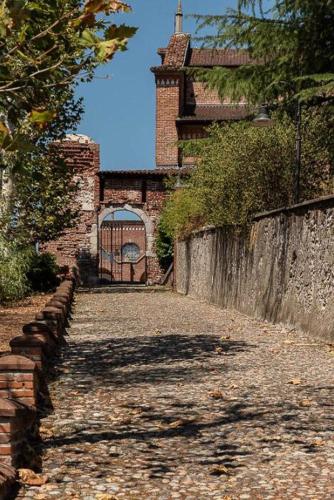 a stone road leading to a building with a gate at Appartamento BELVEDERE in Castiglione Olona