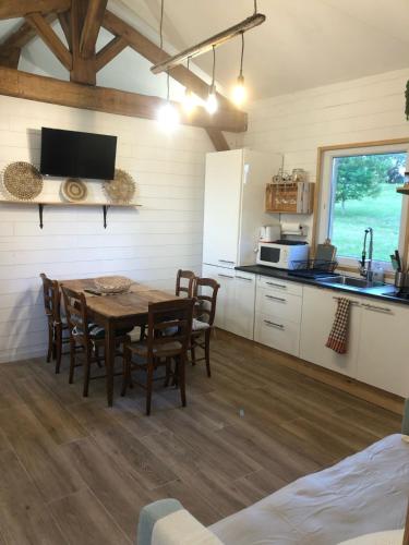 une cuisine et une salle à manger avec une table et des chaises dans l'établissement Gîte au cœur des Landes, à Lue