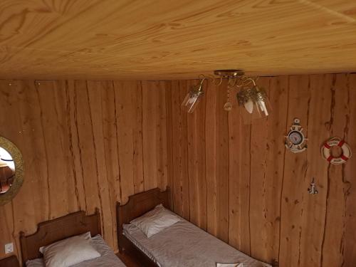 a bedroom with two beds in a wooden wall at Brīvdienu māja ar kopējo virtuvi in Salacgrīva