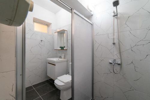 a white bathroom with a toilet and a shower at Saxe - Cozy Apartment in Bodrum in Bodrum City