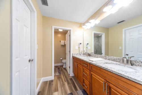 baño con 2 lavabos y espejo grande en Edgewater Villa 2112, en Panama City Beach