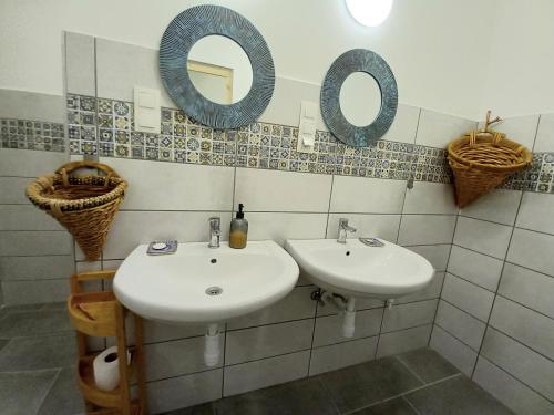 La salle de bains est pourvue de 2 lavabos et de miroirs sur le mur. dans l'établissement Home of arts and creation, Erdei alkoto studio, à Kismaros
