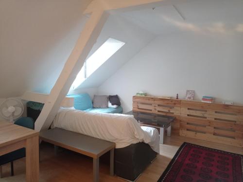 sypialnia z łóżkiem i ławką na poddaszu w obiekcie Gemütliche Dachwohnung w mieście St. Gallen