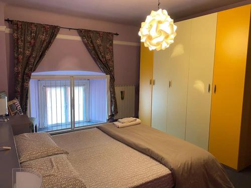 1 dormitorio con 1 cama con ventana y lámpara de araña en Rainbow House, en Intra