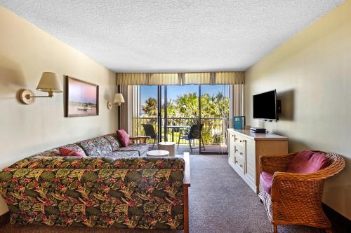 uma sala de estar com um sofá e uma televisão num quarto em The Beach Club at St. Augustine em Saint Augustine Beach