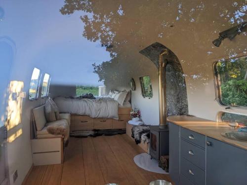 a room with a bed and a sink in a room at Airstream, vintage American caravan & Hottub in Ashburton