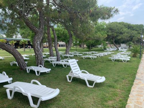a group of white lounge chairs in a park at BUNGALOV in Kemer