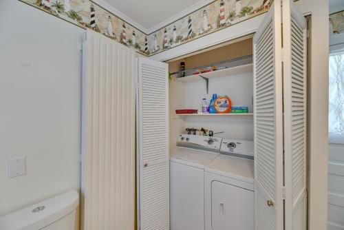 a small kitchen with white cabinets and floral wallpaper at Lovely Hammondsport Home, Walk to Keuka Lake! in Hammondsport